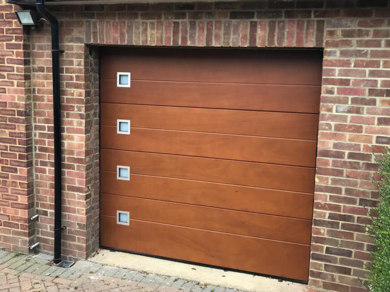 Sectional garage door - okoume clad with windows